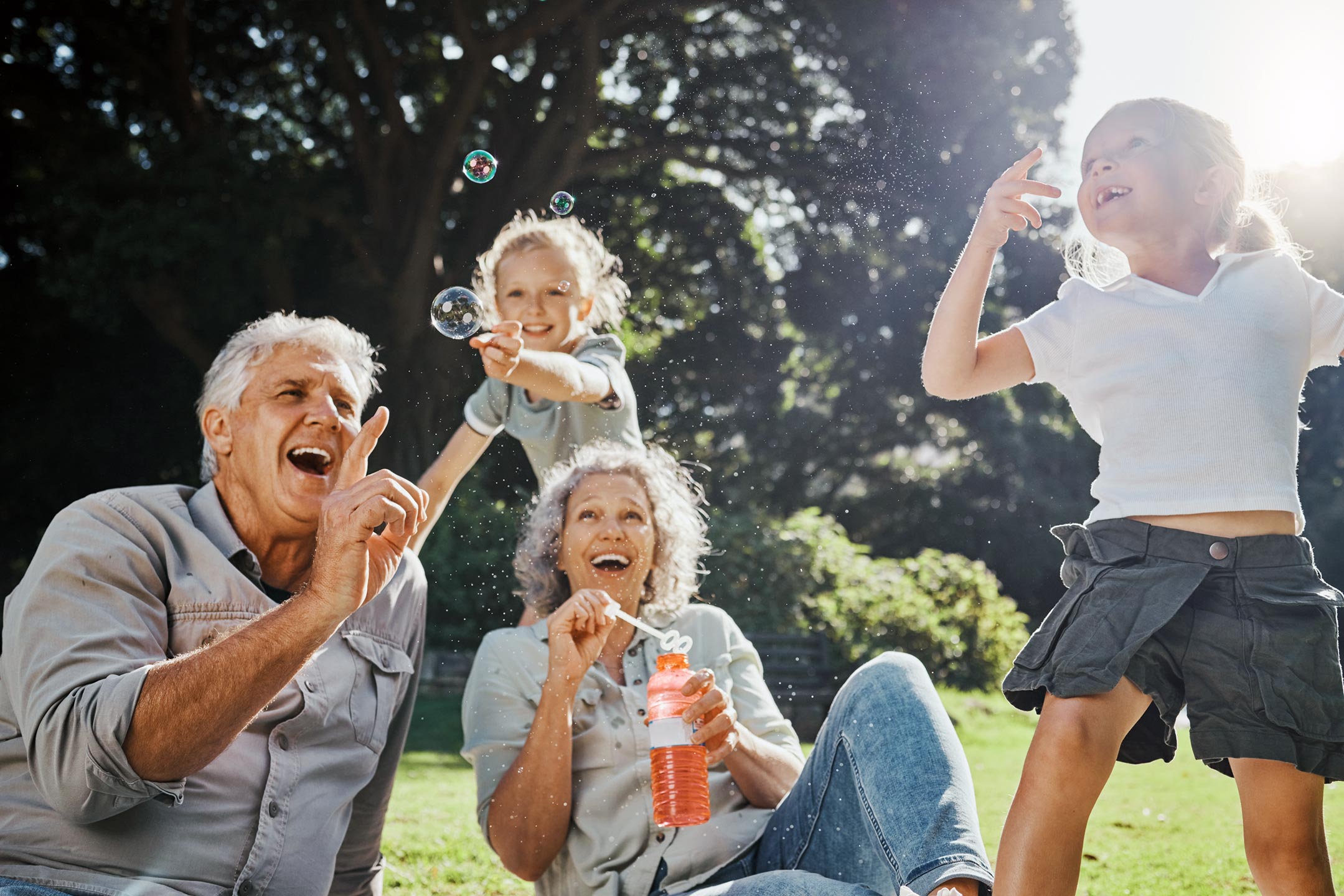 Happy-grandparents-playing-with-their-grandchildren-in-a-park Happy-grandparents-playing-with-their-grandchildren-in-a-park
