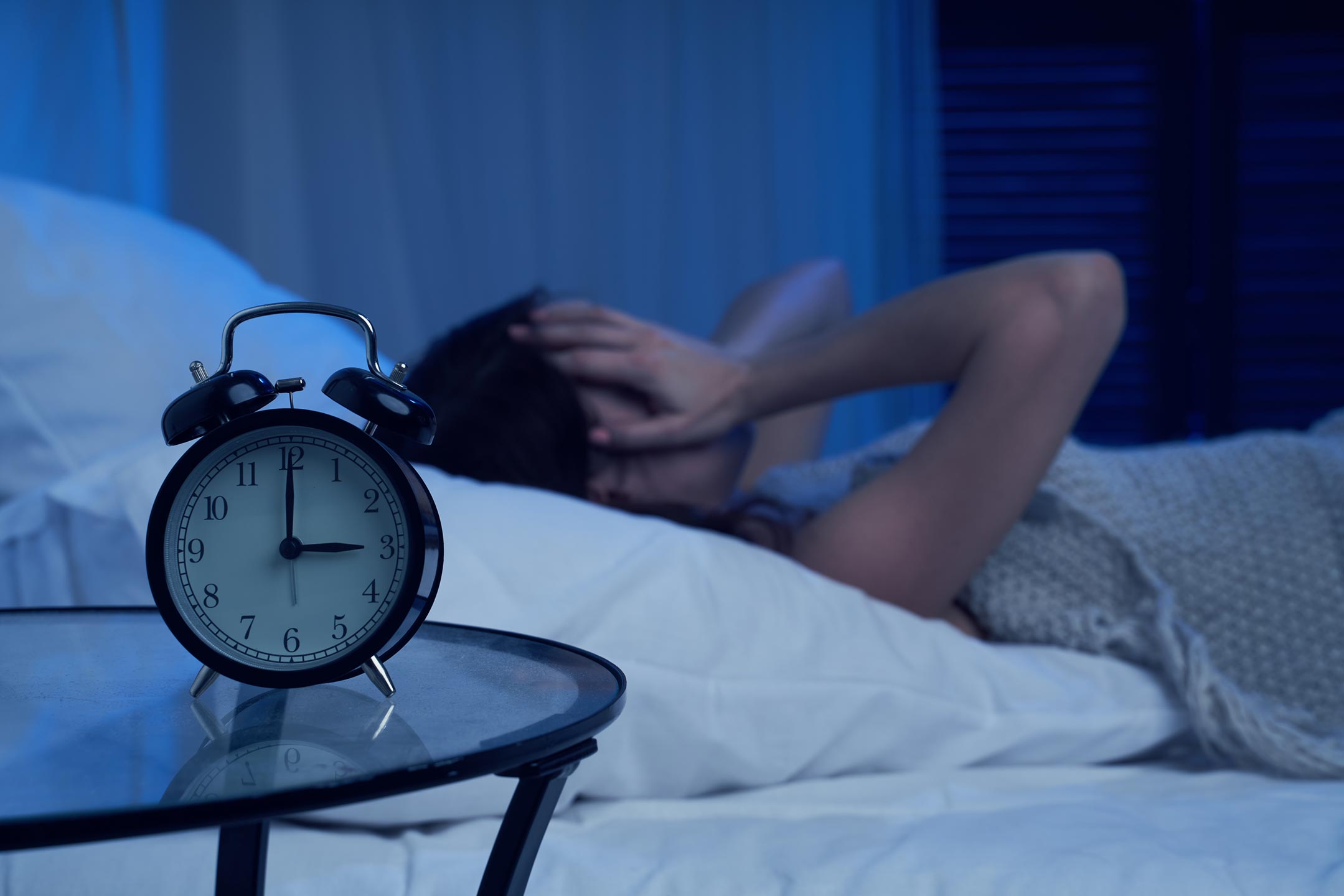 Woman lying awake in bed at night staring at ceiling — perimenopause sleep disruption and hormone imbalance